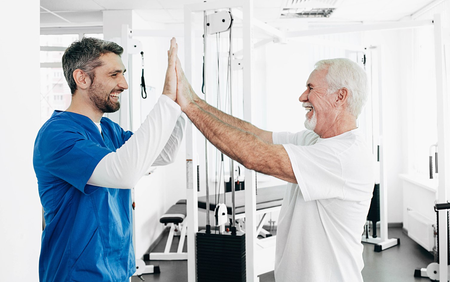 Senior man and Physical Therapist have five after successful physio treatment. physio rehabilitation